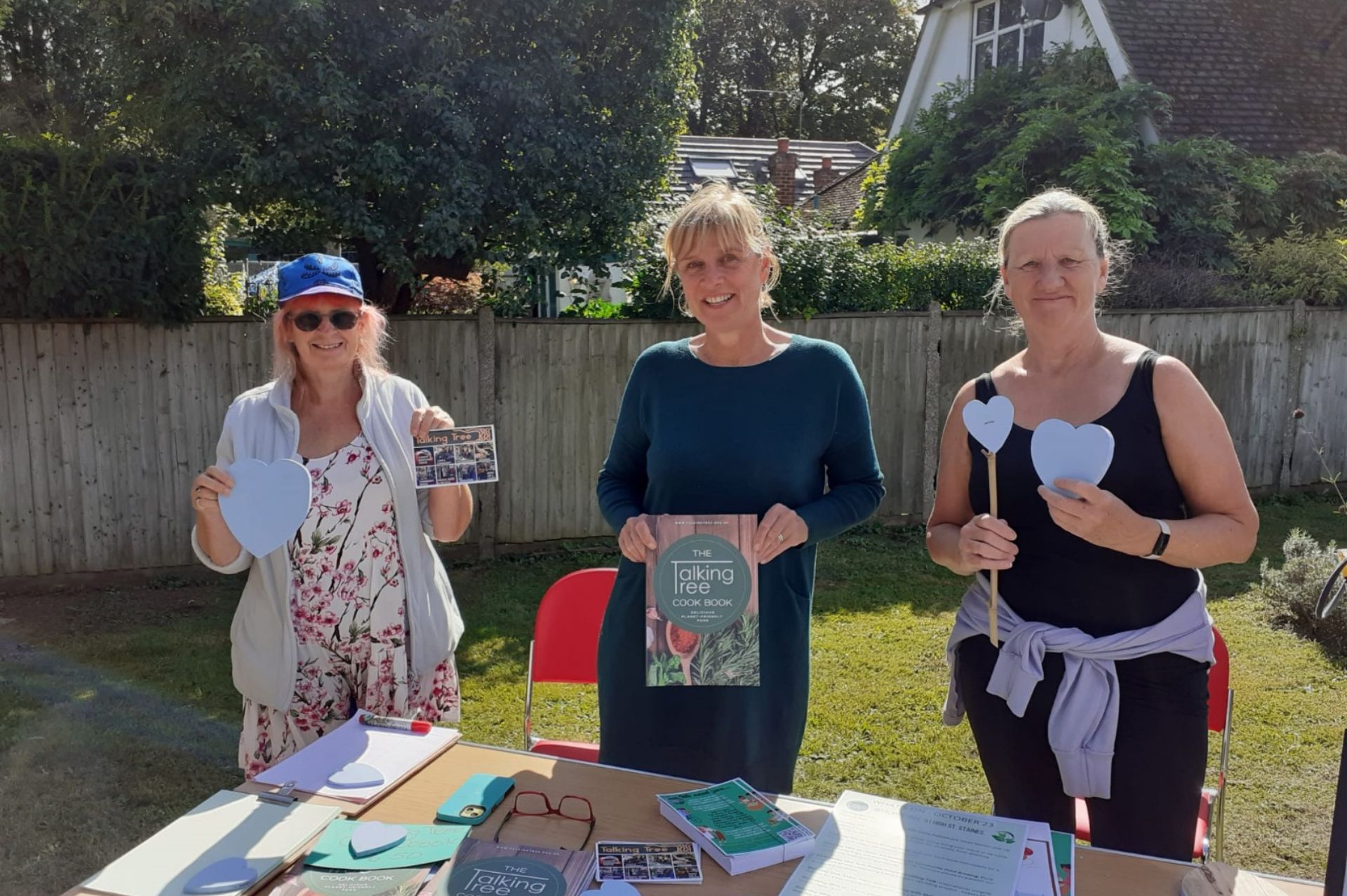 Three ladies stood holding up eco themed craft