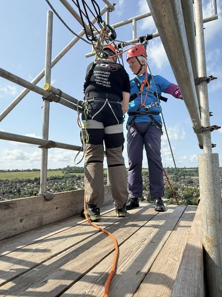 Bishop Andrew being harnessed up ready for his abseil from the top of Guildford Cathedral's tower