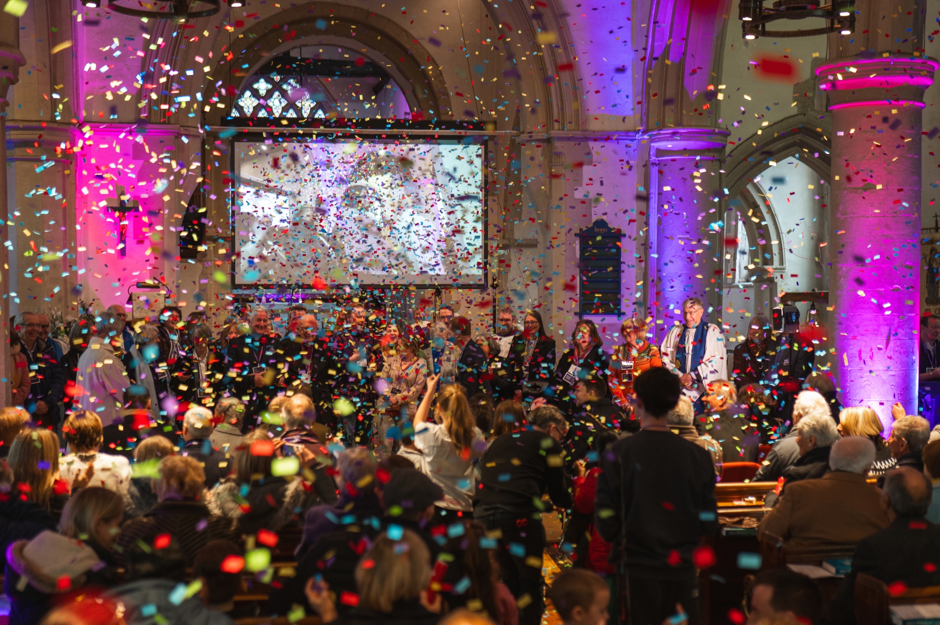 Party streamers falling inside a church building with the congregation smiling