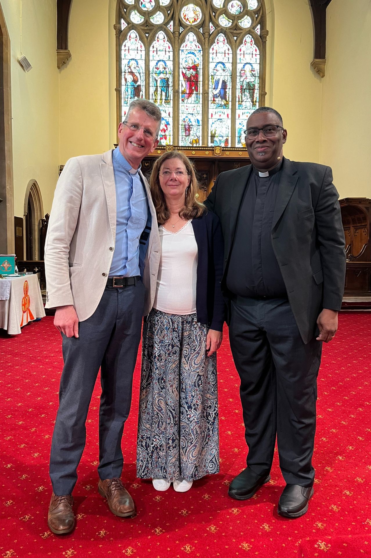 George and Jane Newton stand with Dean Pusey on the stage at Holy Trinity Aldershot