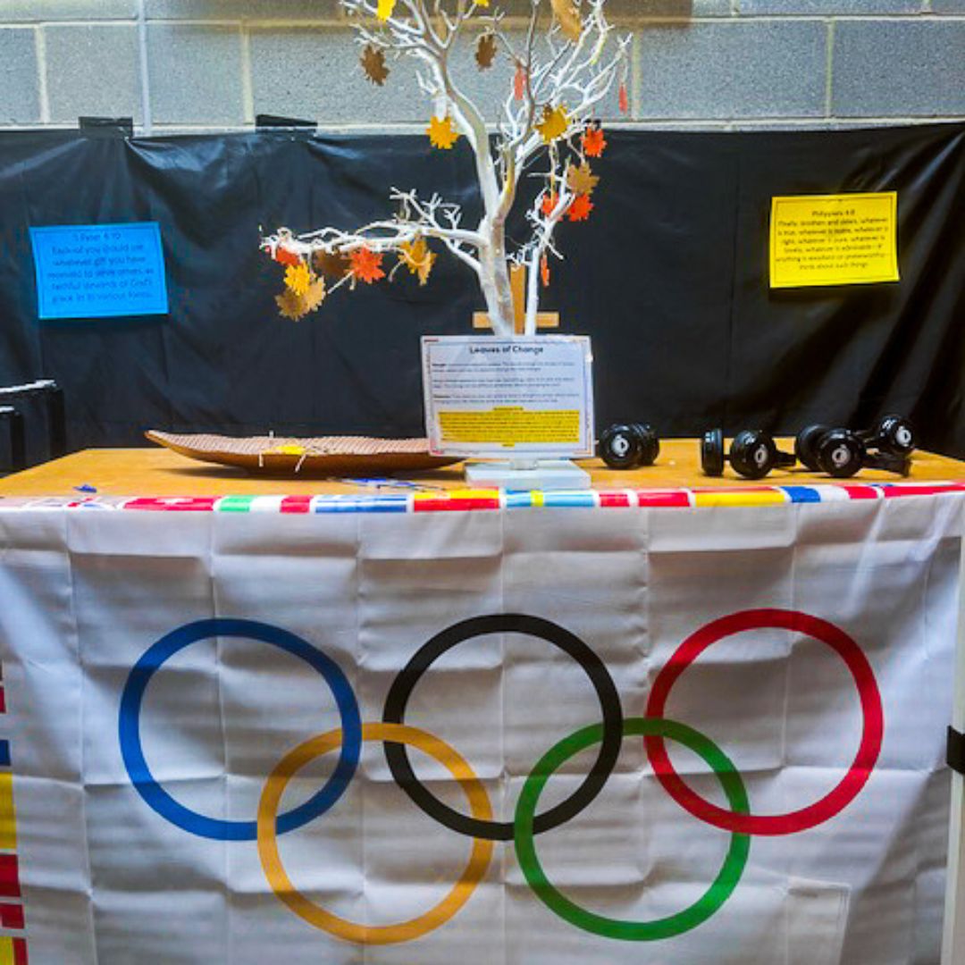 A table with a prayer tree on with the Olympic flag hanging from it