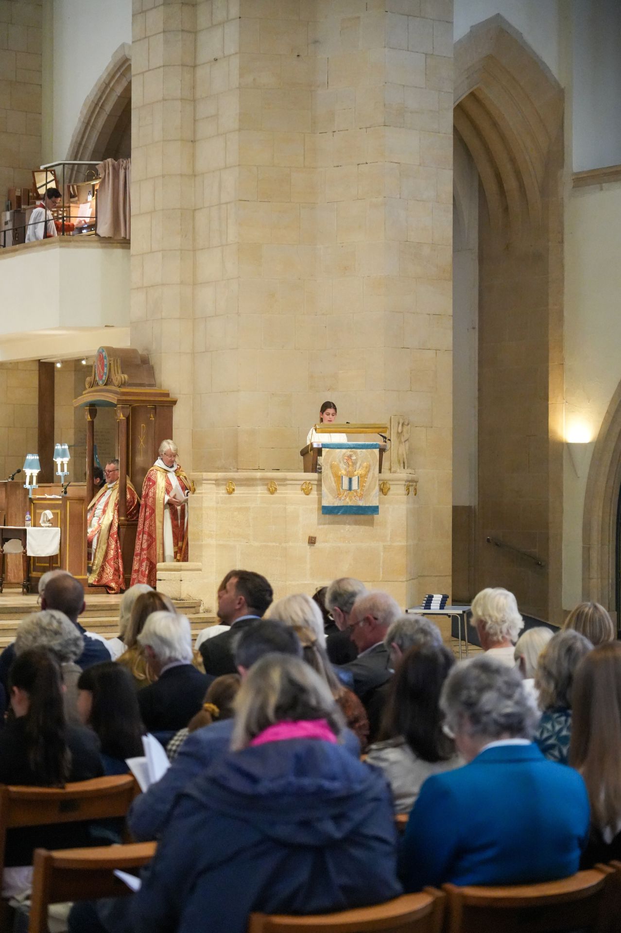 Charlotte stands in the pulpit in Guildford Cathedral giving the reading to the congregation