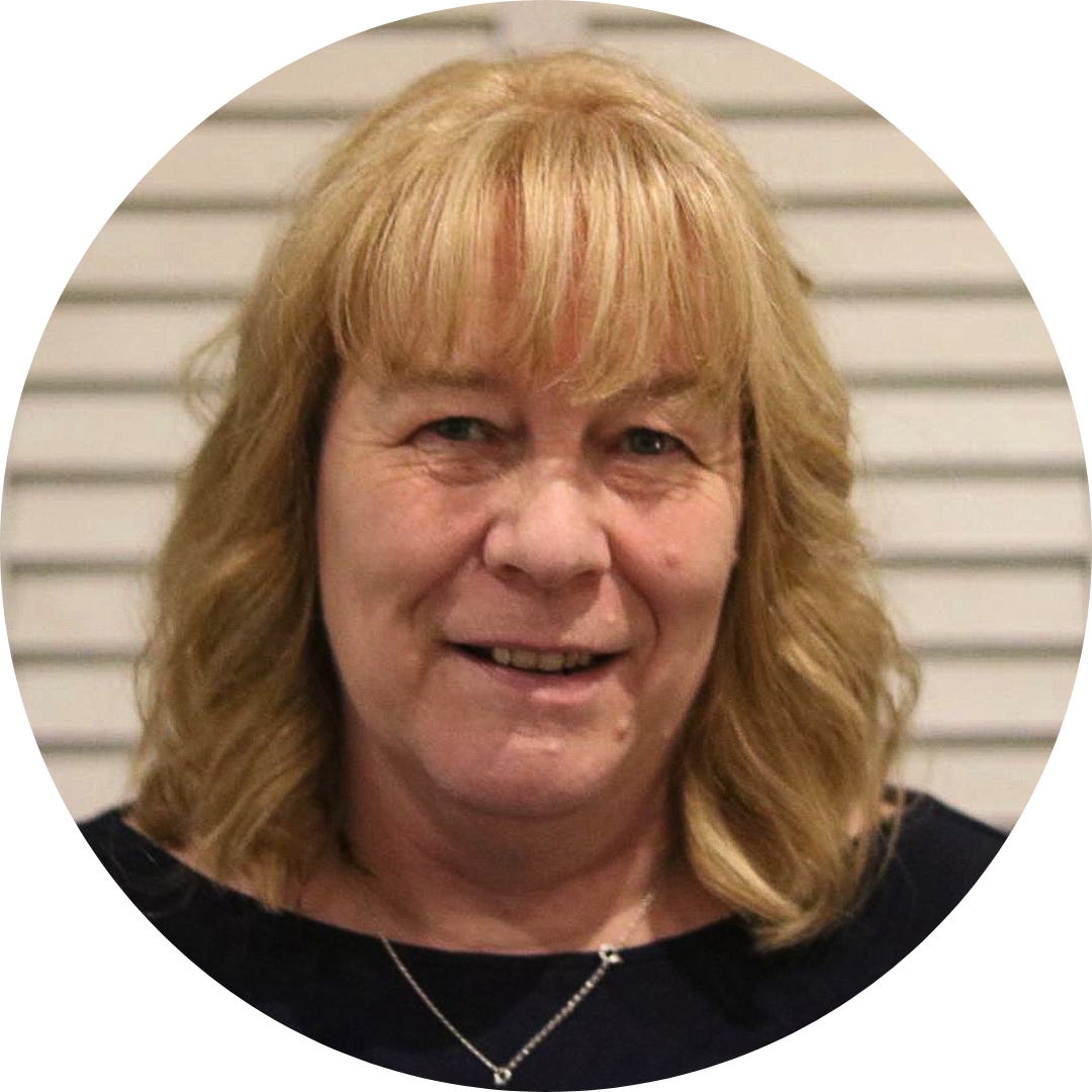 Sara Holland in a dark top and wearing a chain neckless