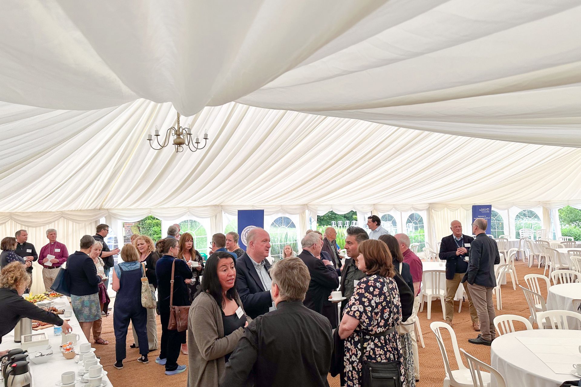 Community leaders in conversation in a large events tent