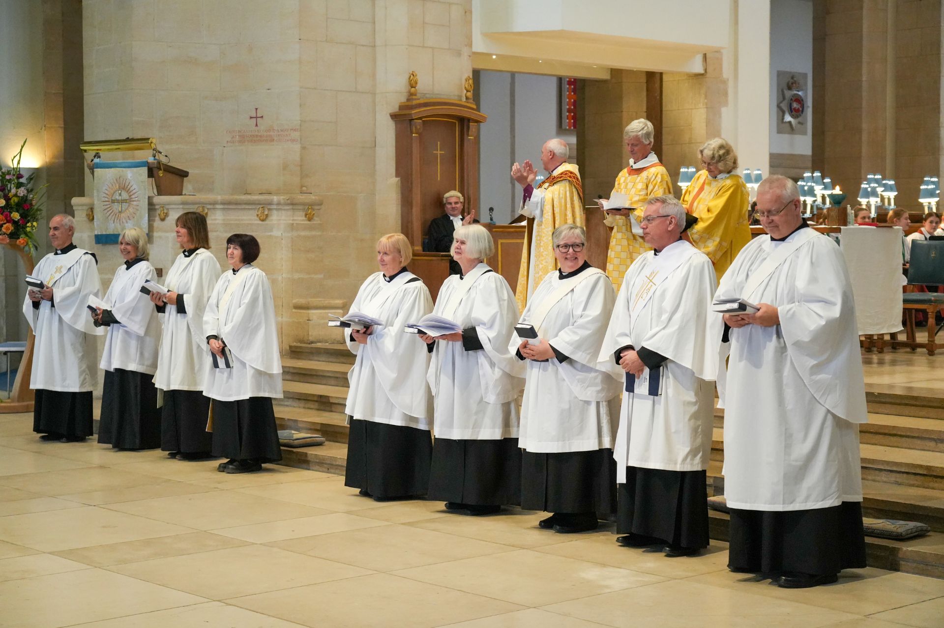 The nine new deacons stand facing the congregation as they are applauded having just been ordained