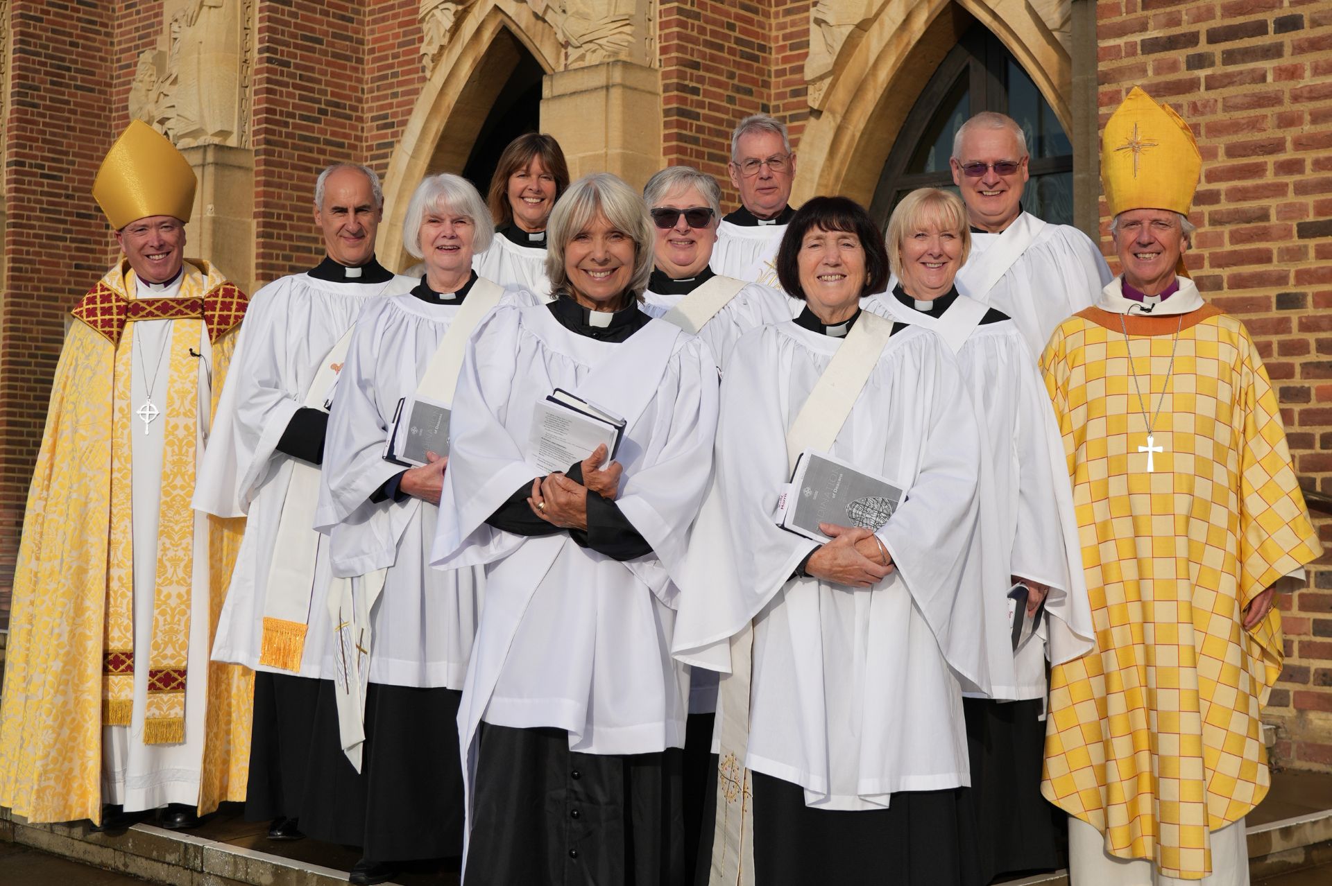 The nine new deacons gather with the Bishops of Guildford and Dorking on the steps of Guildford Cathedral
